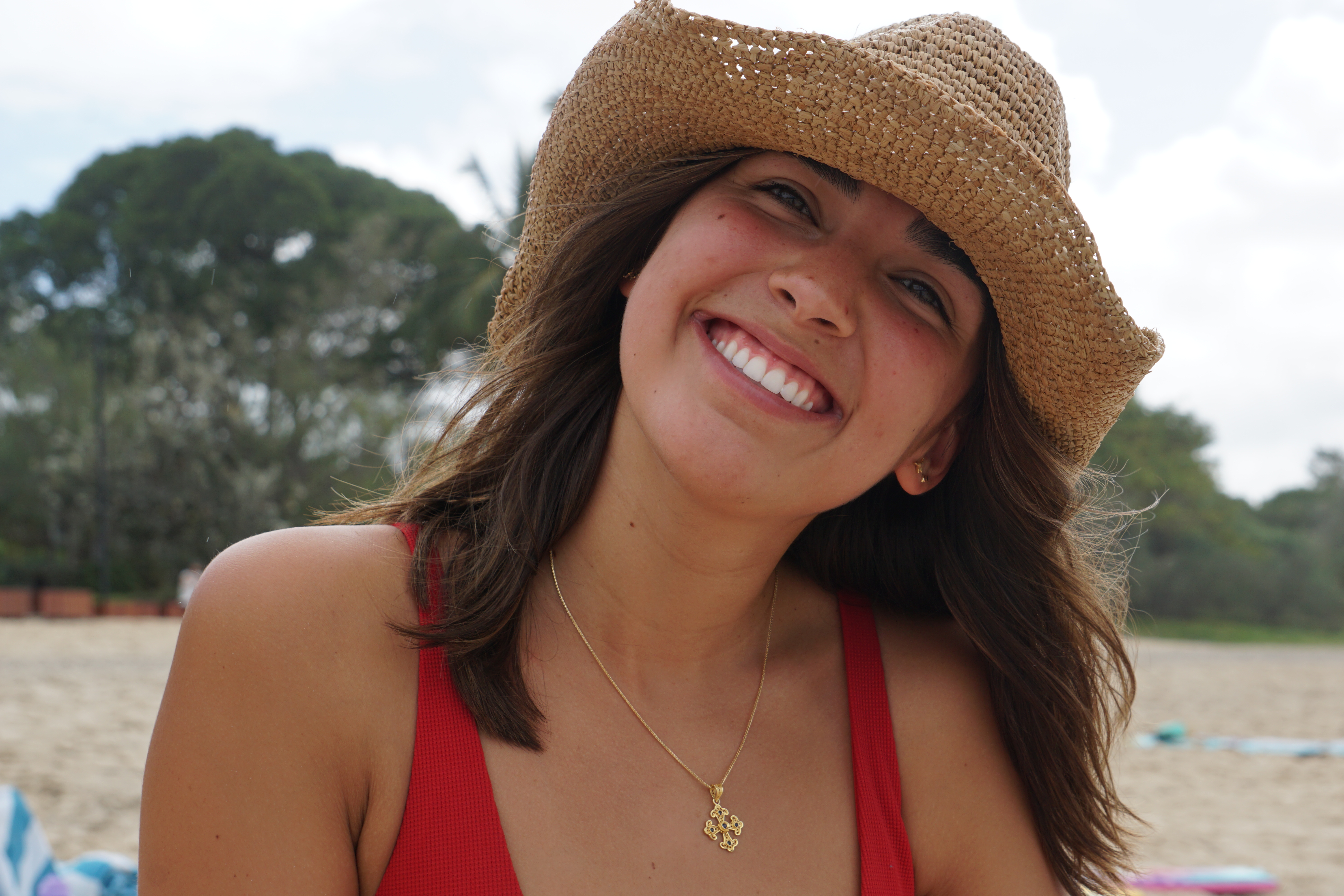 Portrait of Carolina Alvarez wearing a straw hat on the beach
